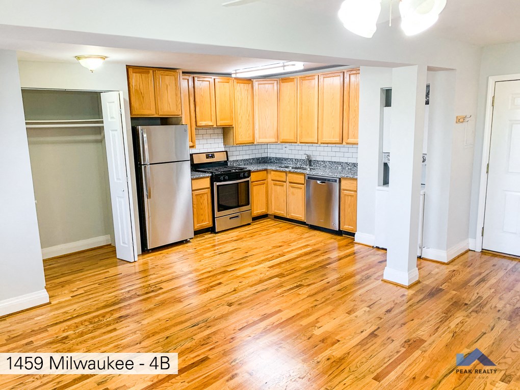 a kitchen with wooden floors and stainless steel appliances