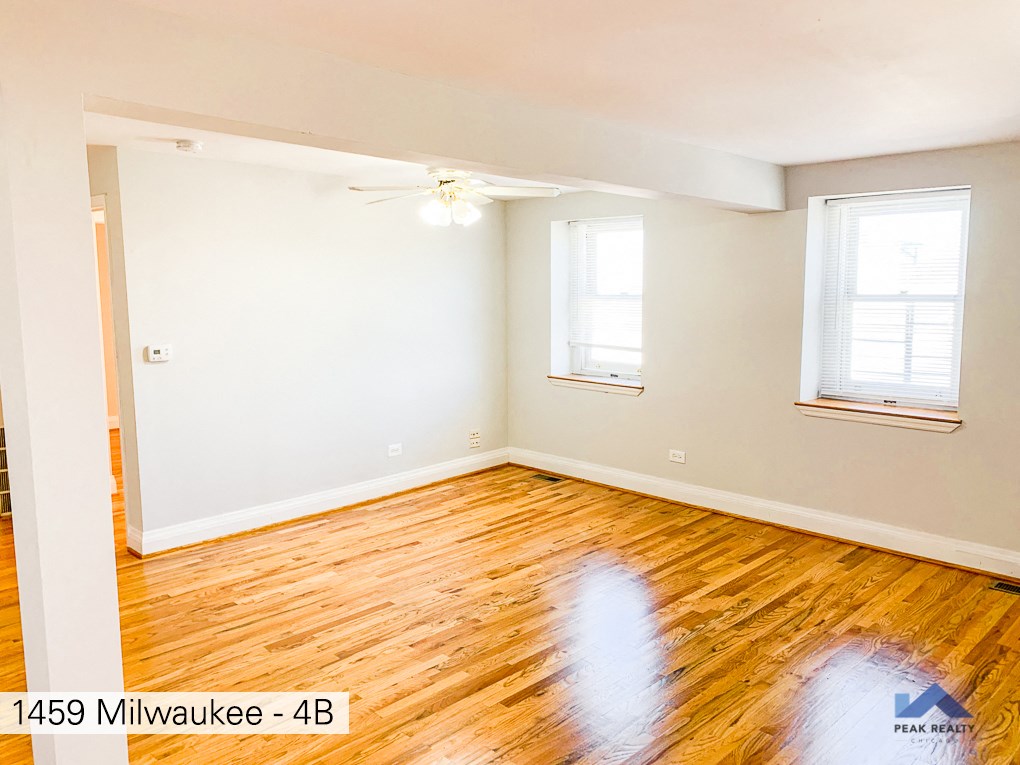 an empty room with wood floors and a ceiling fan