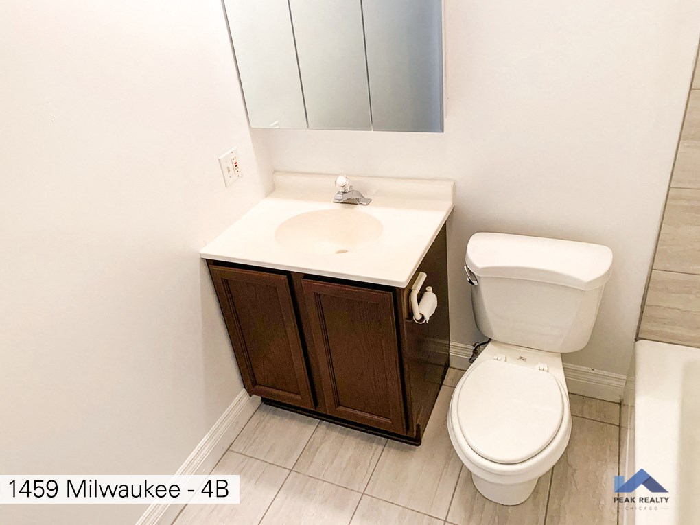 a bathroom with a toilet and a sink and a mirror