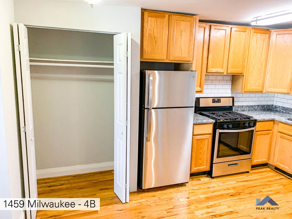 a kitchen with a stainless steel refrigerator and wooden cabinets