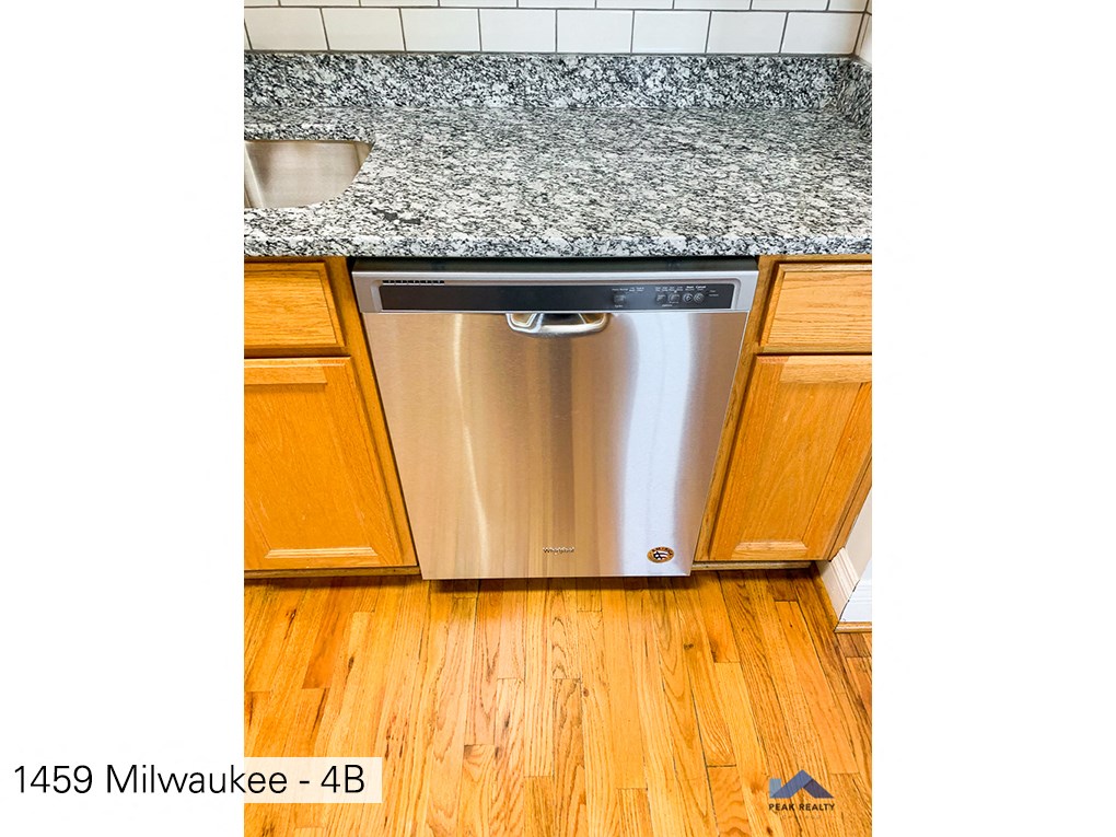 a stainless steel dishwasher in a kitchen with wood floors
