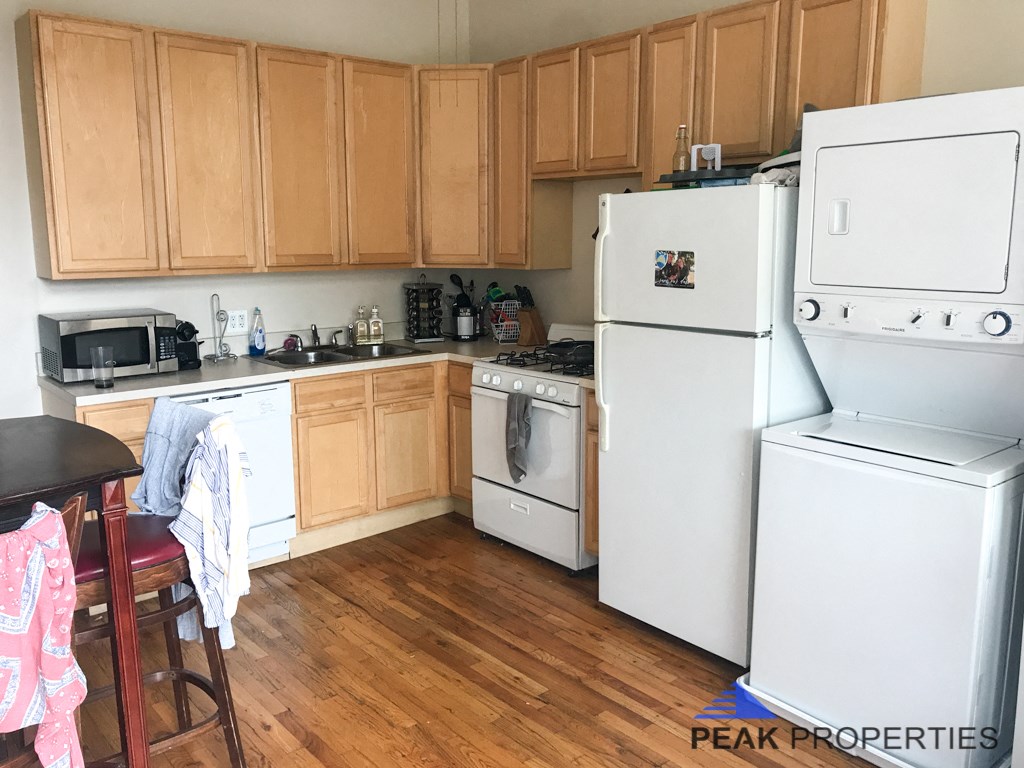 a kitchen with white appliances and wooden cabinets