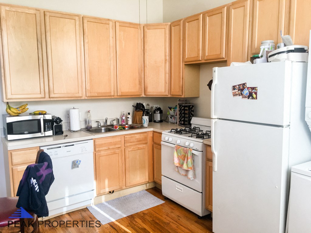 a kitchen with white appliances and wooden cabinets