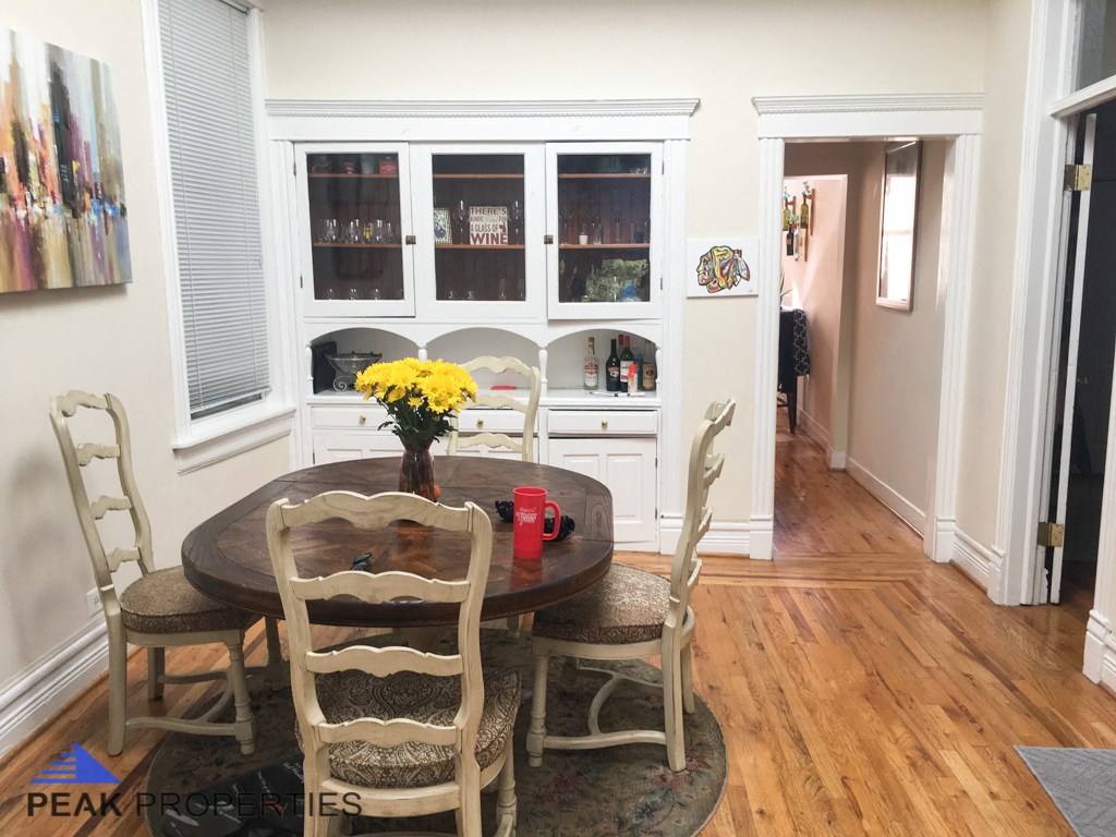 a dining room with a table and chairs in front of a window