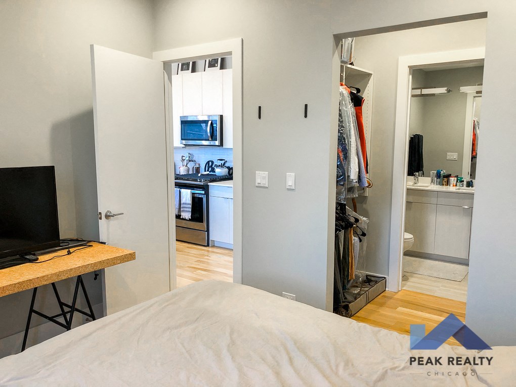 a bedroom with a bed and a closet and a kitchen