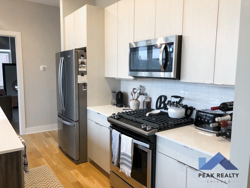 a kitchen with white cabinets and a stove and a refrigerator