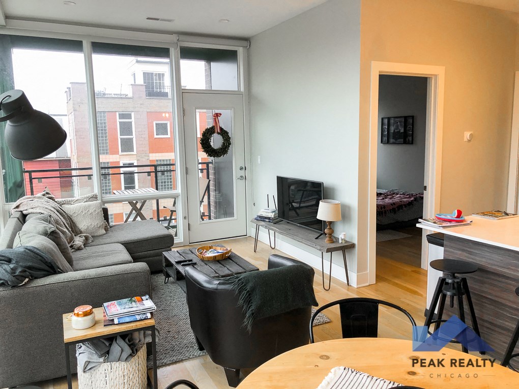 a living room with a couch and a tv and a balcony