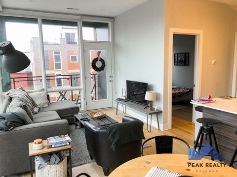 a living room with a couch and a tv and a balcony