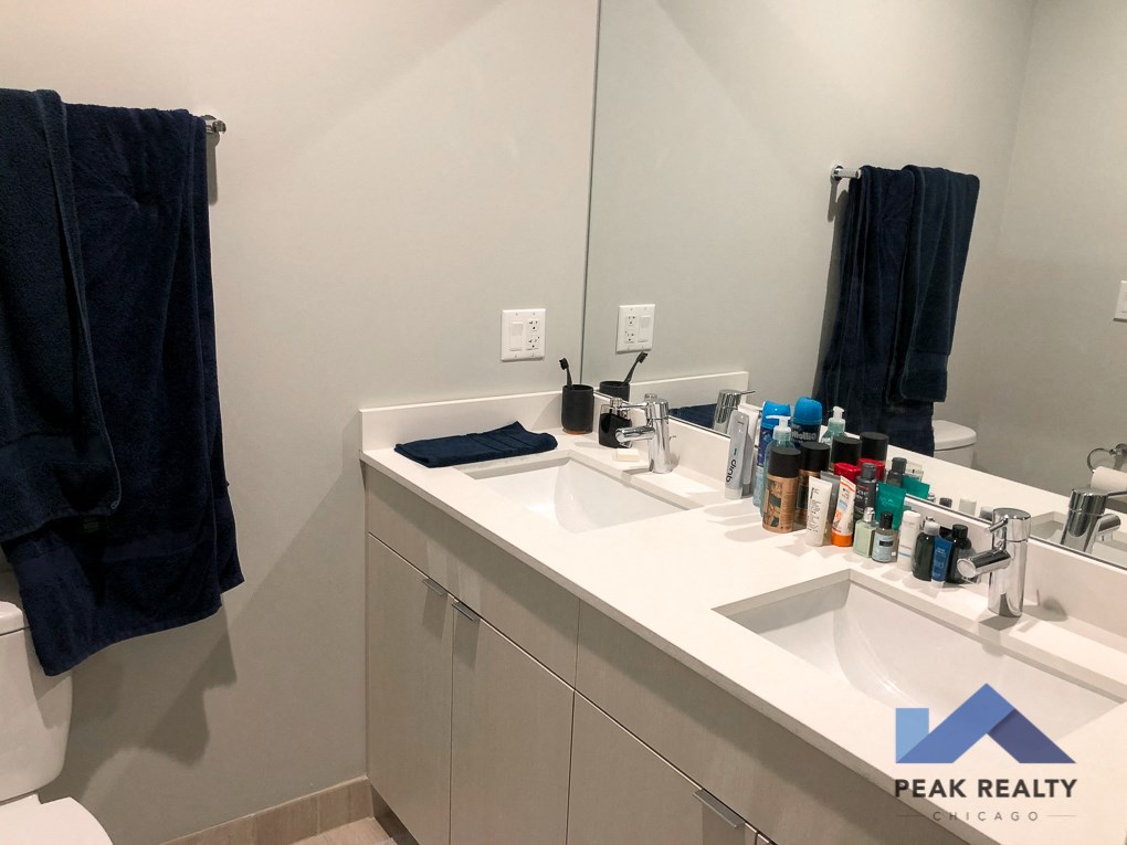 a white bathroom with two sinks and a mirror