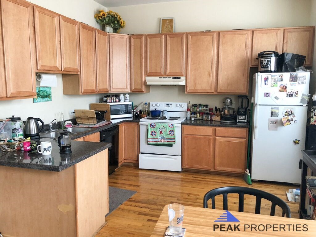 a kitchen with white appliances and wooden cabinets