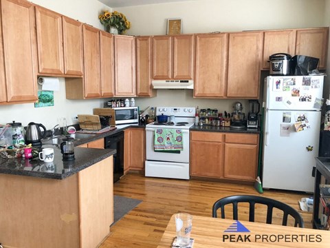 a kitchen with white appliances and wooden cabinets