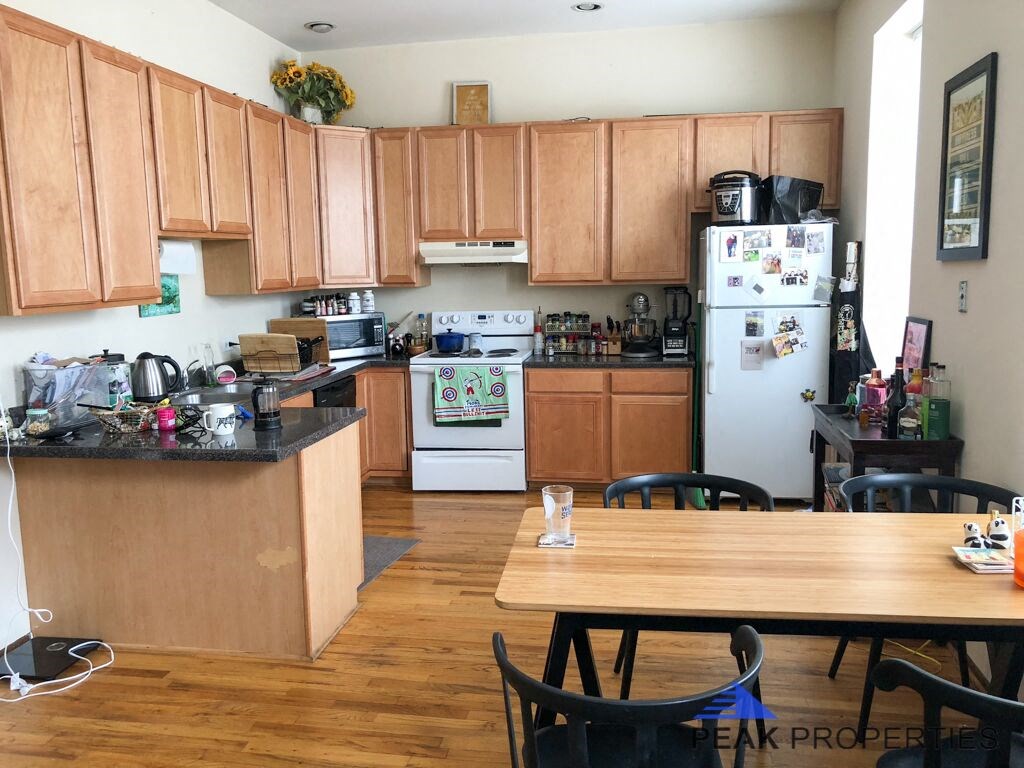 a kitchen with wooden cabinets and a wooden table