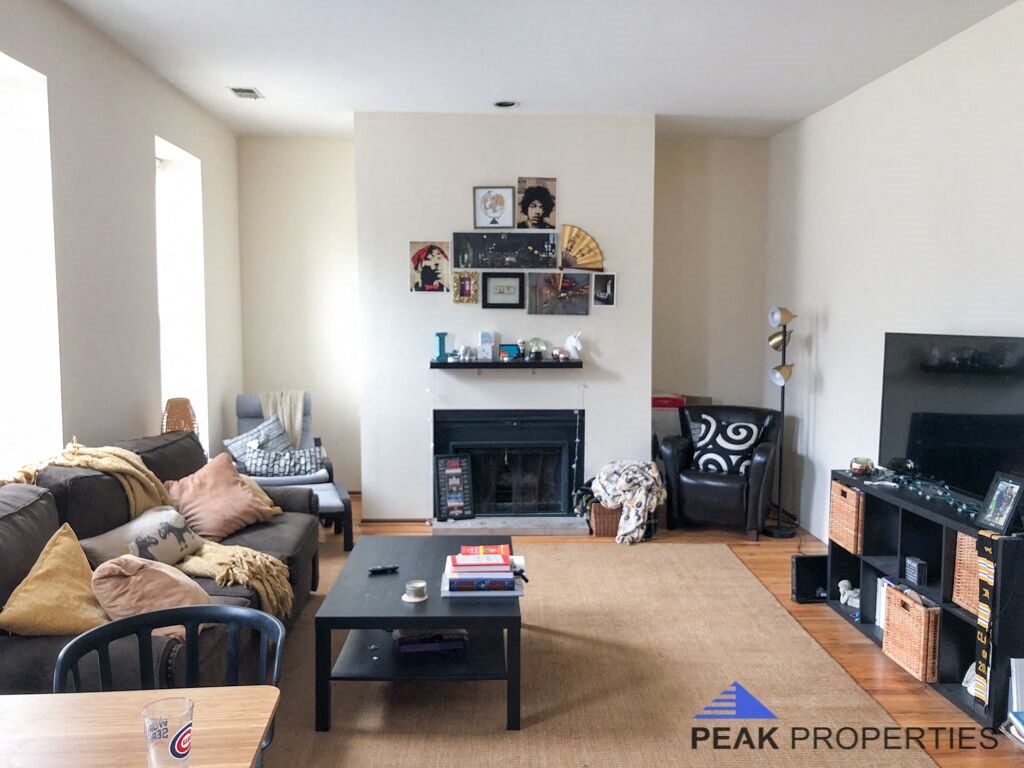 a living room with a couch and a table and a fireplace