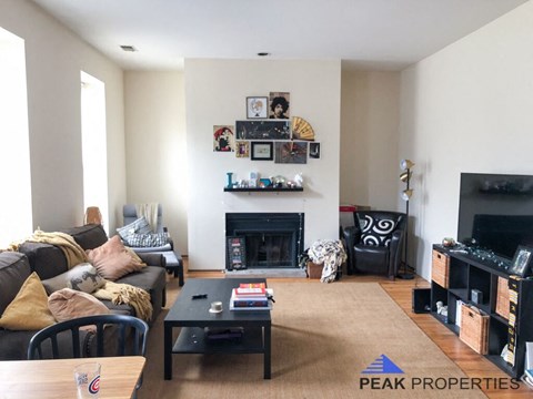 a living room with a couch and a table and a fireplace