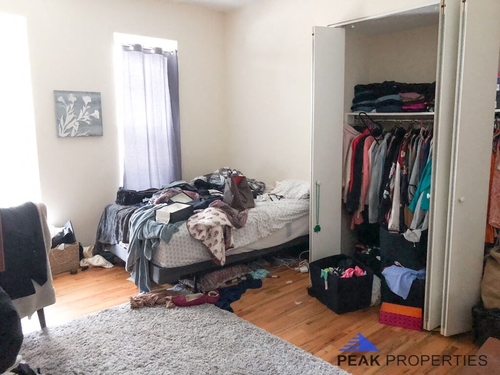 a bedroom with a closet full of clothes and a bed in it