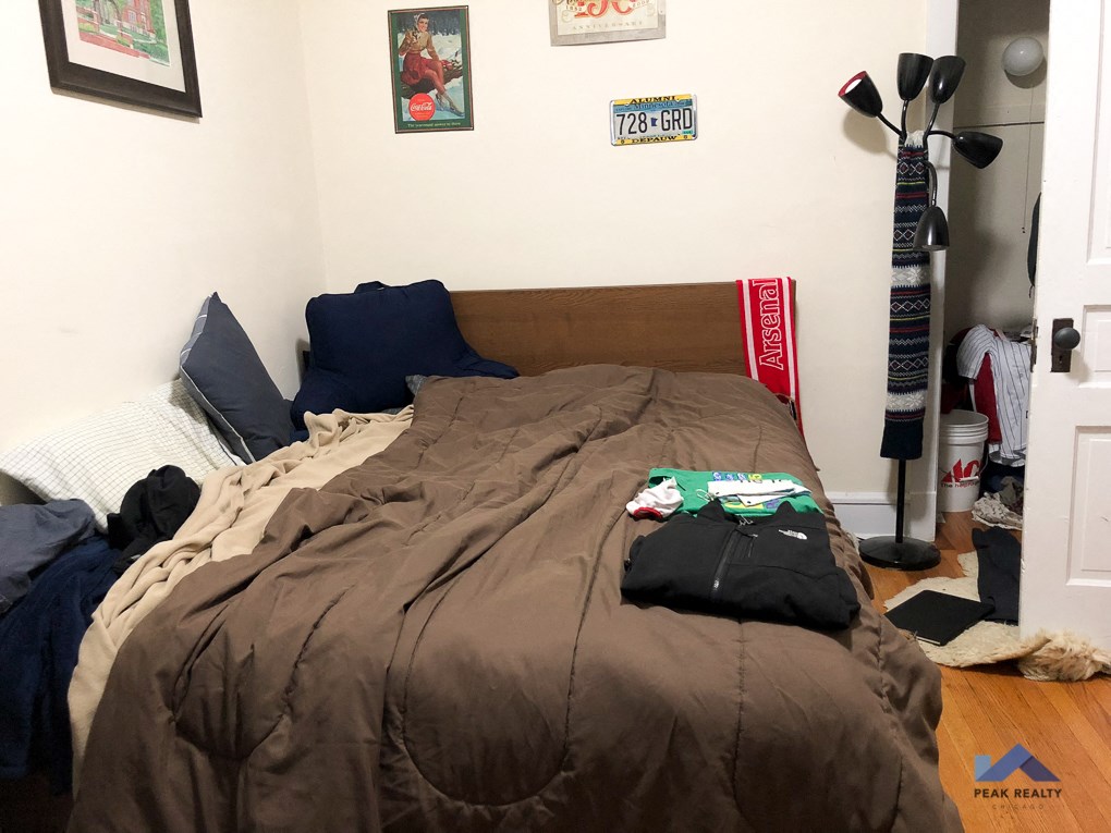 a bedroom with a bed with a brown comforter