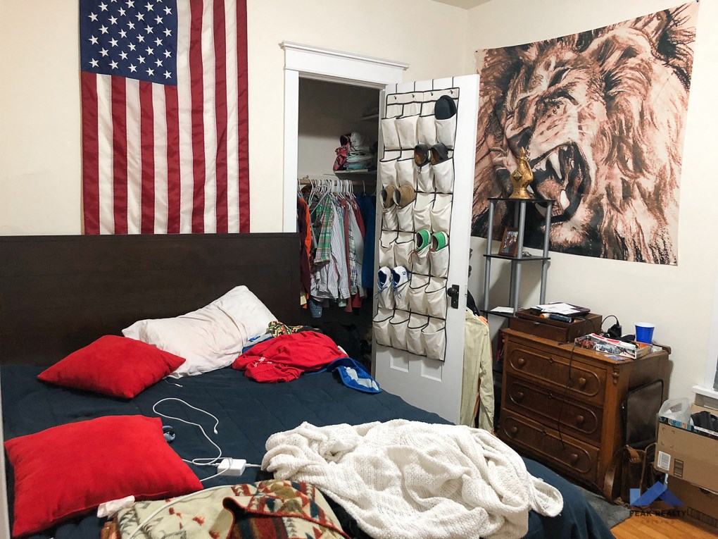 a bedroom with a bed and an flag on the wall