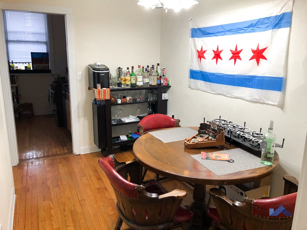 a dining room with a table and chairs and a flag on the wall