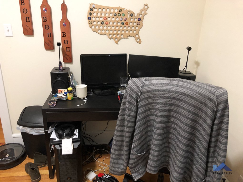 my desk in my room with a blanket on it and a computer