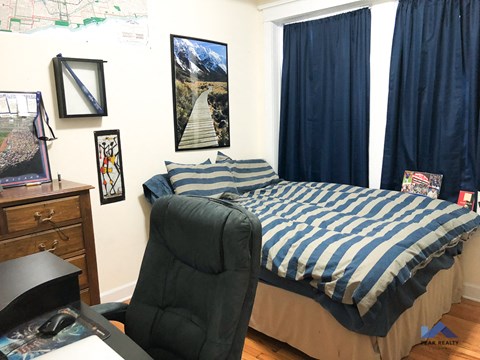 a bedroom with a bed and a desk and a chair