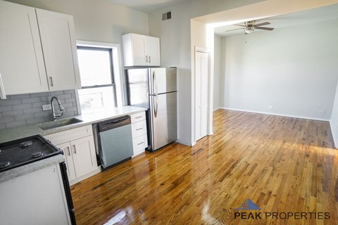 A kitchen with wooden floors and white appliances.
