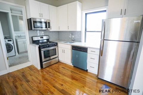 A kitchen with wooden floors and stainless steel appliances.