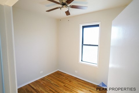 A room with a ceiling fan and a window.