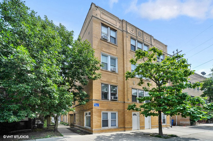 a brick building with trees in front of it