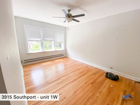the living room of a home with wood floors and a ceiling fan