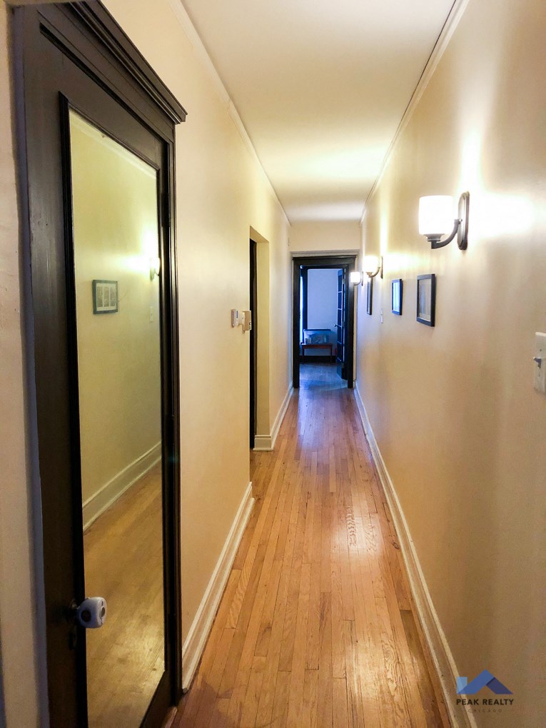 a hallway with a wooden floor and a door