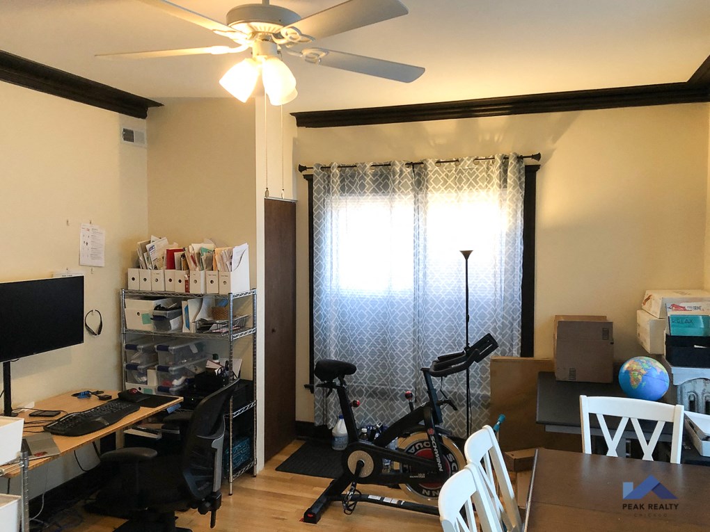 a home office with a desk and a bike in front of a window