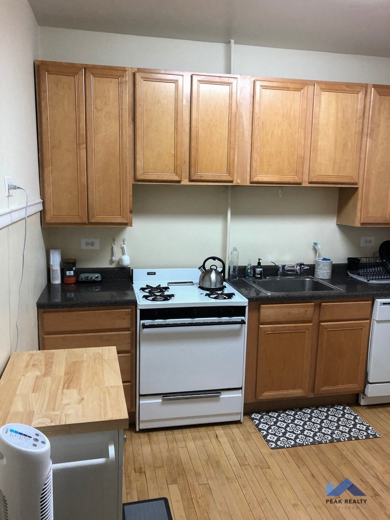 a kitchen with a white stove and wooden cabinets