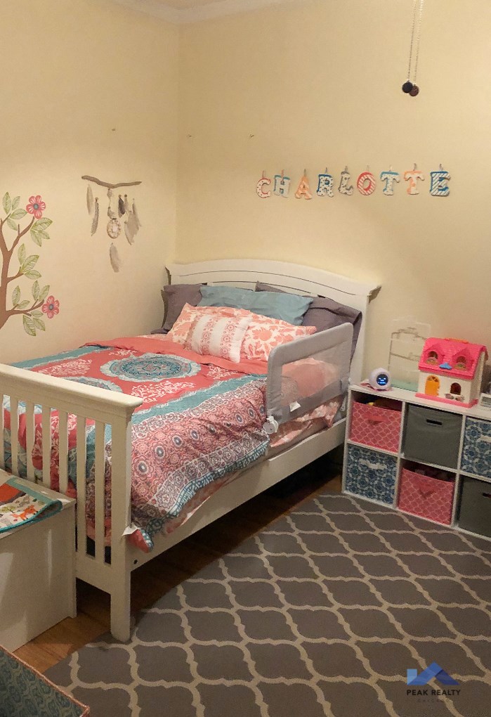 a little girl bedroom with a bed and a rug