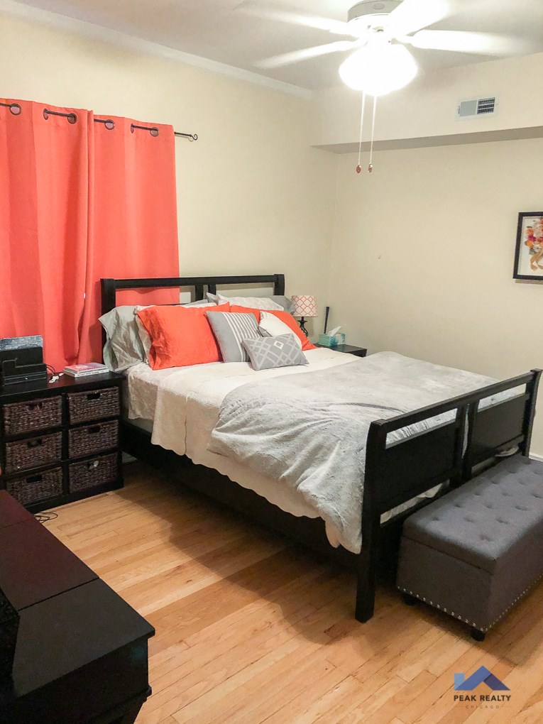 a bedroom with a bed and a dresser and a ceiling fan