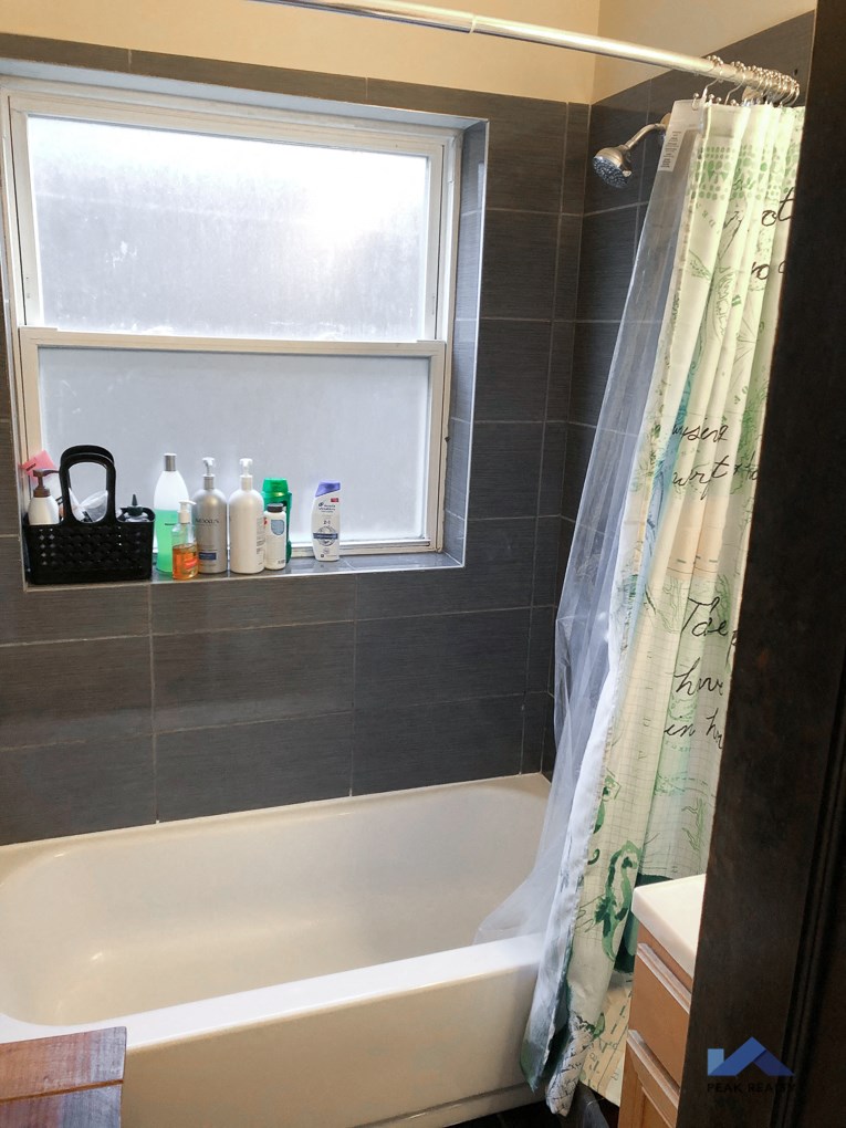 a bathroom with a tub and a window and a shower curtain