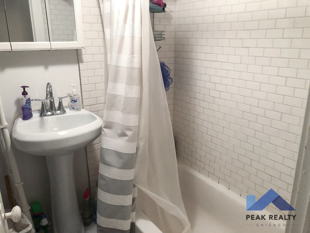 a small bathroom with a sink and a shower curtain