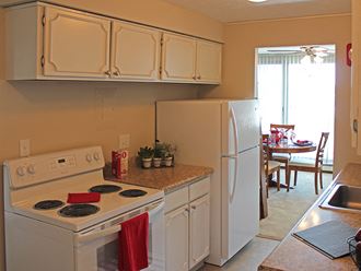 a kitchen with white appliances and white cabinets and a white refrigerator