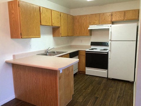A kitchen with wooden cabinets and a white refrigerator.