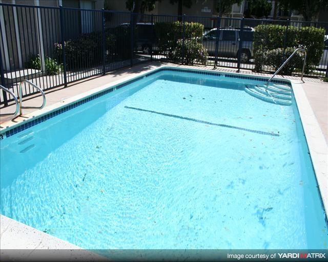 a large blue swimming pool in front of a black fence