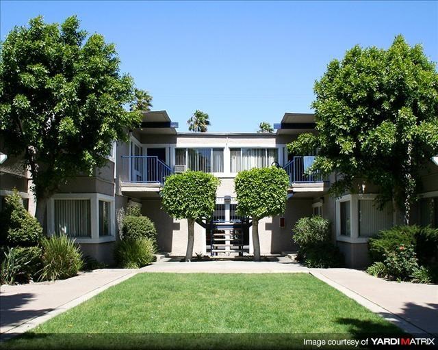 an apartment building with trees in front of it