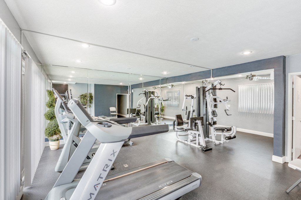 A modern gym with a treadmill and other exercise equipment.