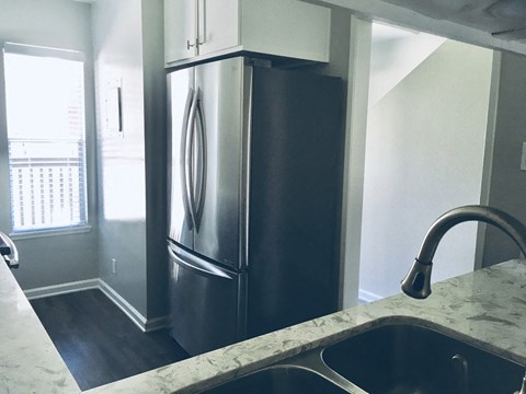 a kitchen with a stainless steel refrigerator and sink