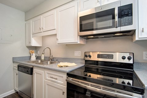 a kitchen with stainless steel appliances and white cabinets