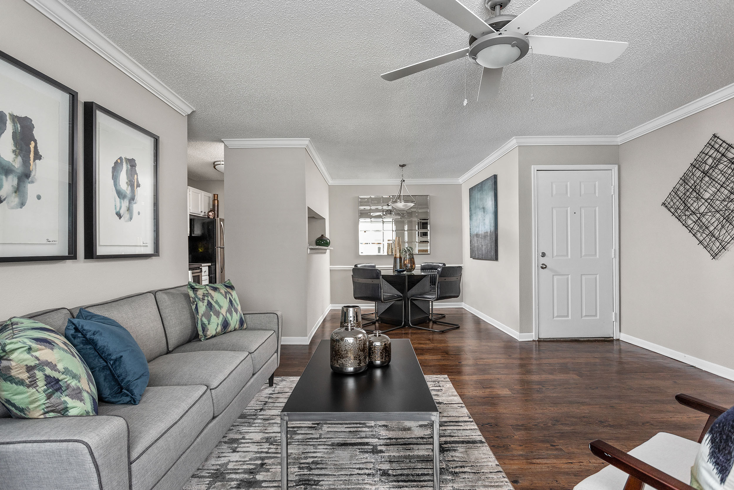 A living room with a grey couch and a black coffee table.