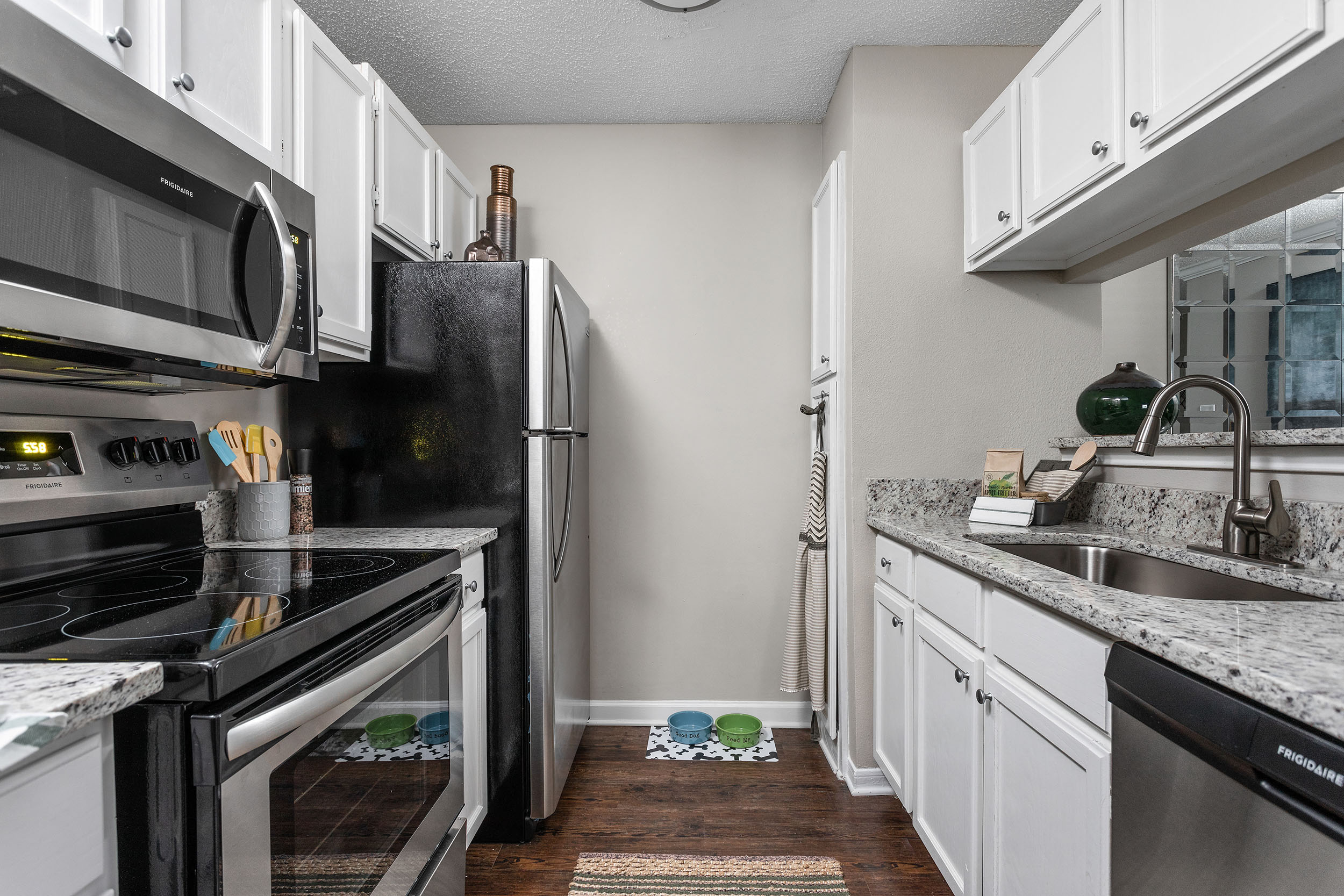 A kitchen with white cabinets and a black stove top oven.