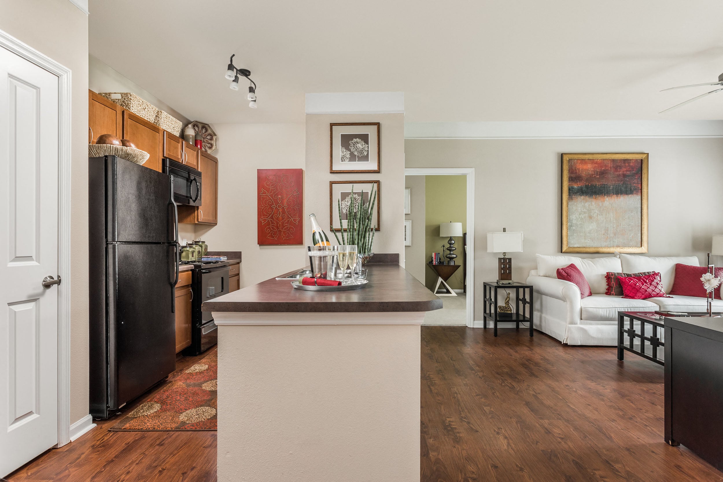 A kitchen with a black refrigerator and a white island.