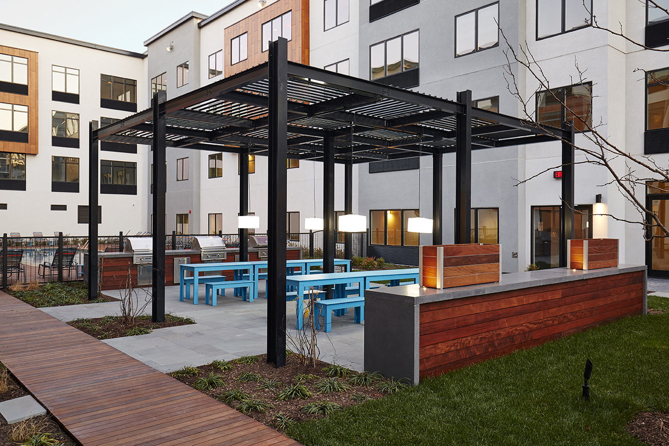 a patio with tables and benches in front of a building