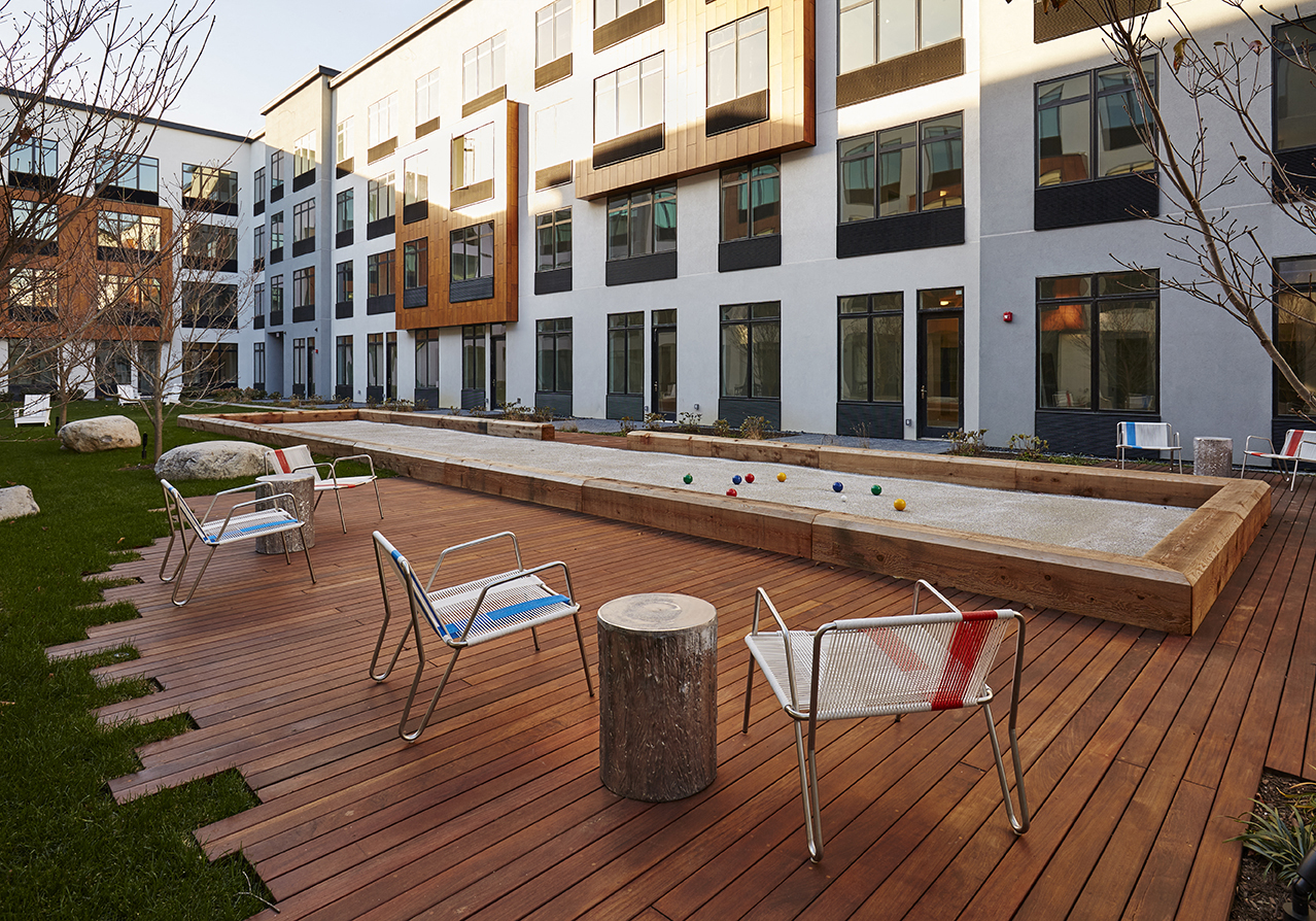 a courtyard with a pool and chairs in front of a building