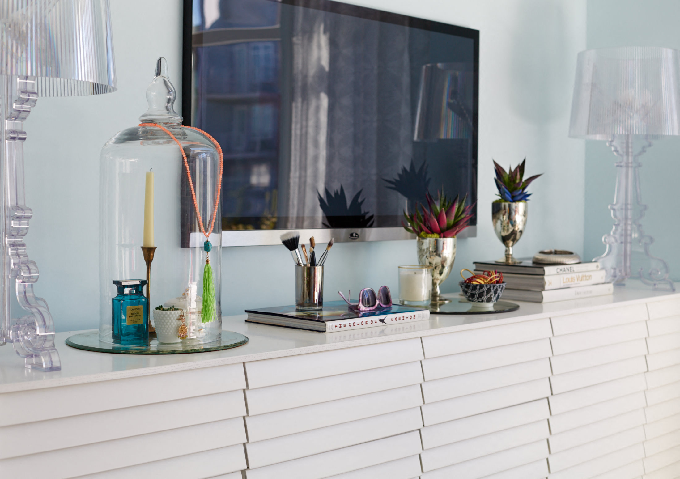 a white dresser with a large mirror and various items on it