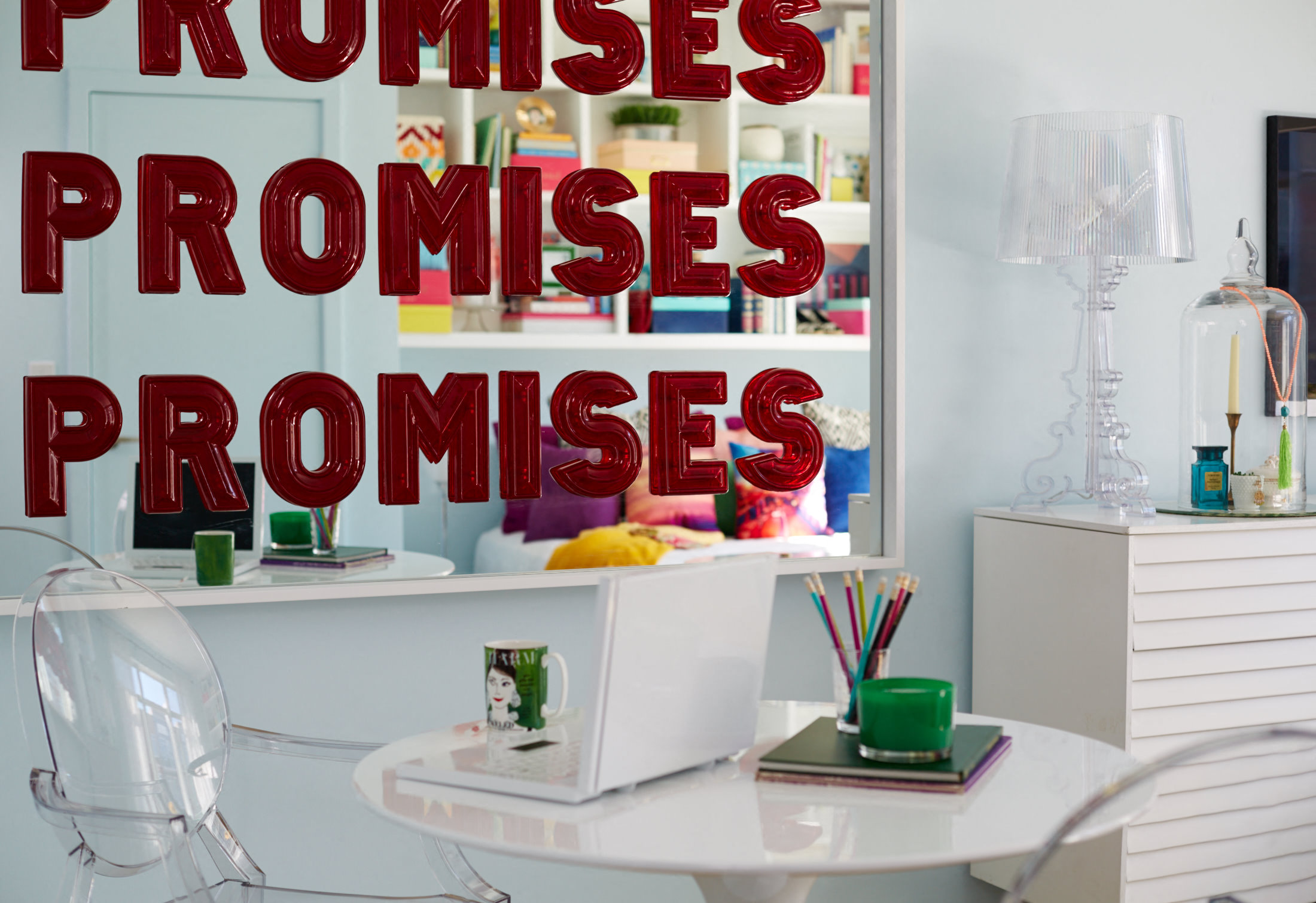a room with a white table and a mirror with the word promises on it
